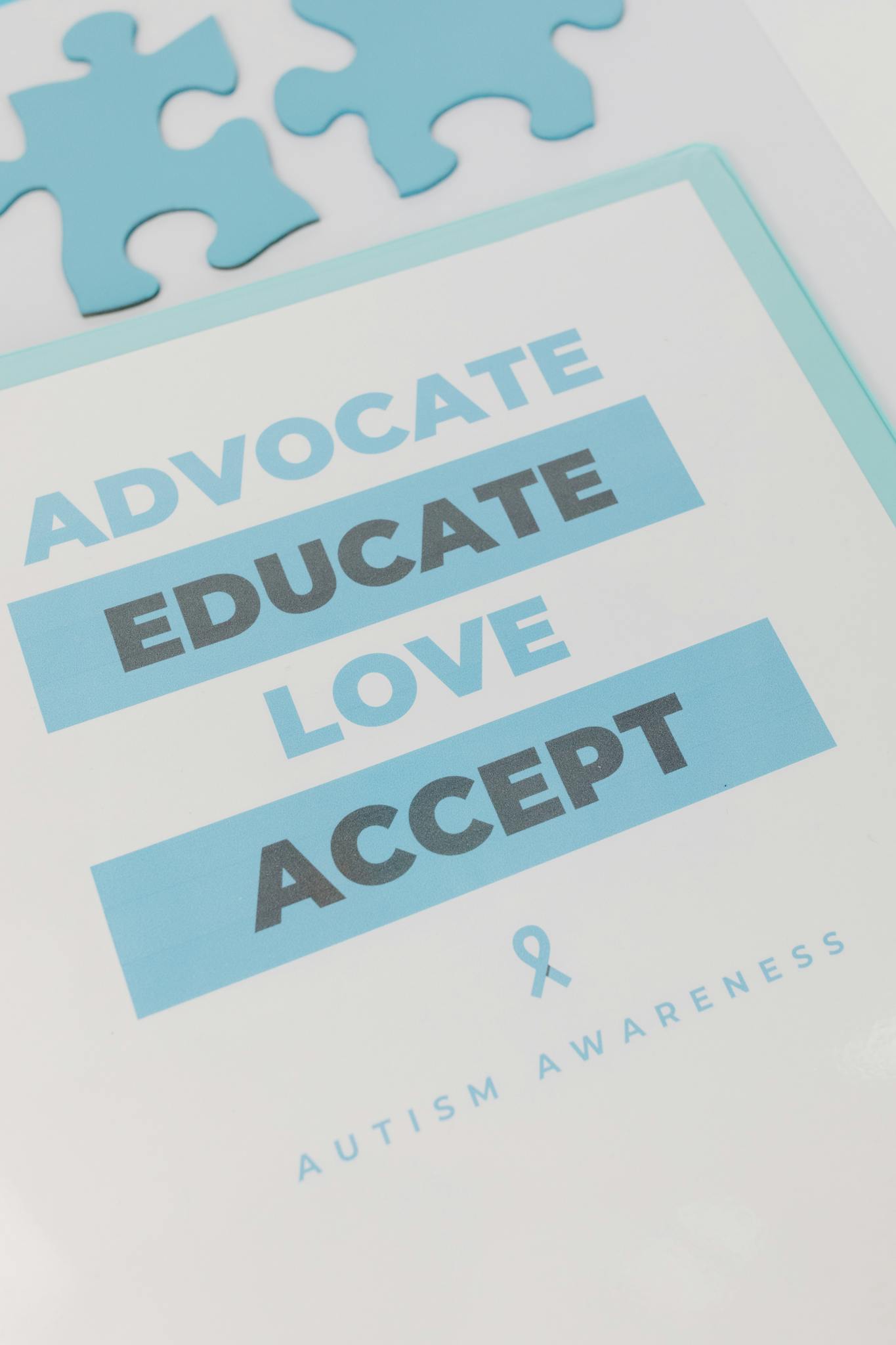 Close-up of a poster promoting autism awareness with blue puzzle pieces and text.