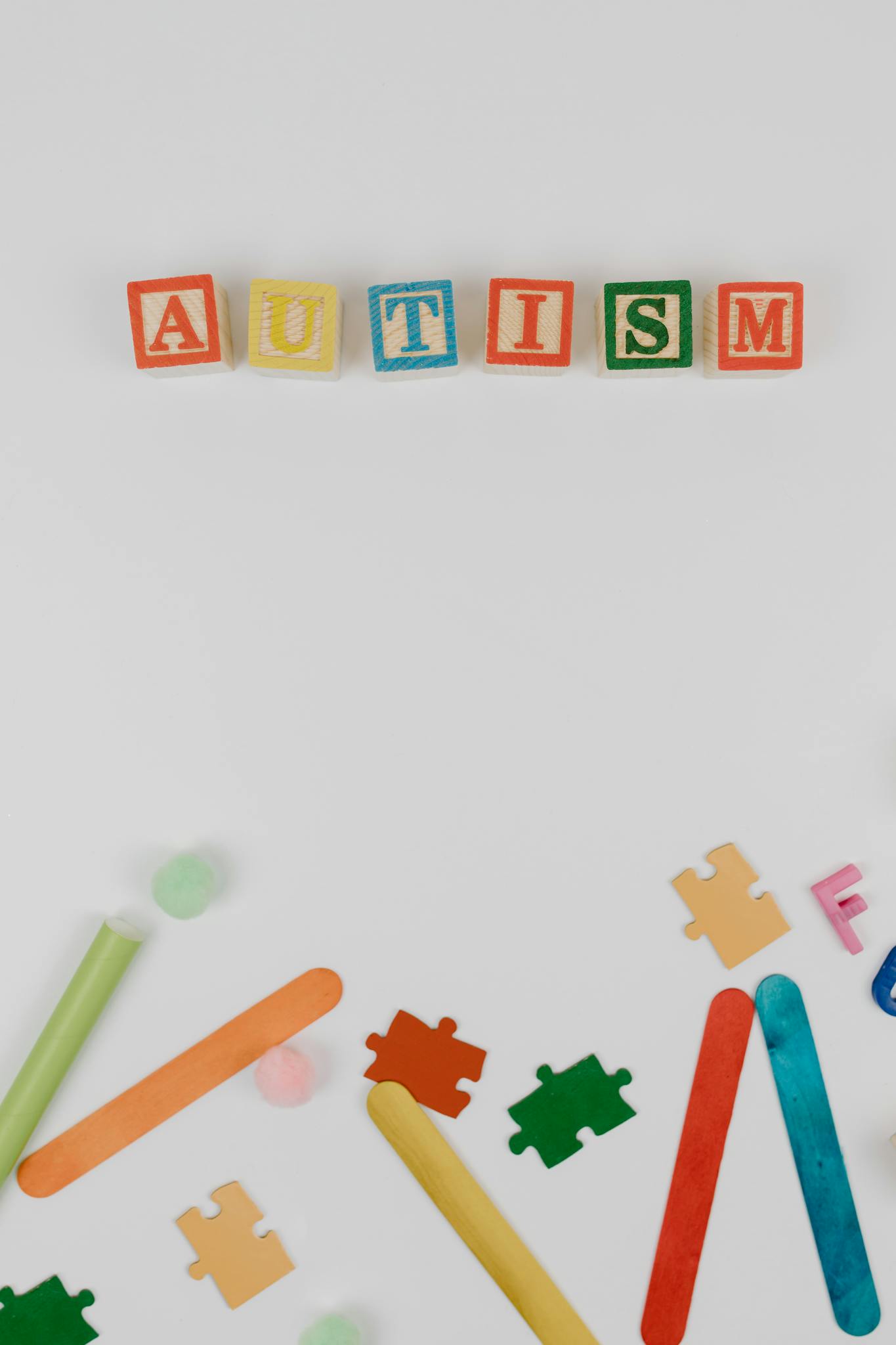 Colorful autism awareness display with blocks and puzzle pieces on a white background.